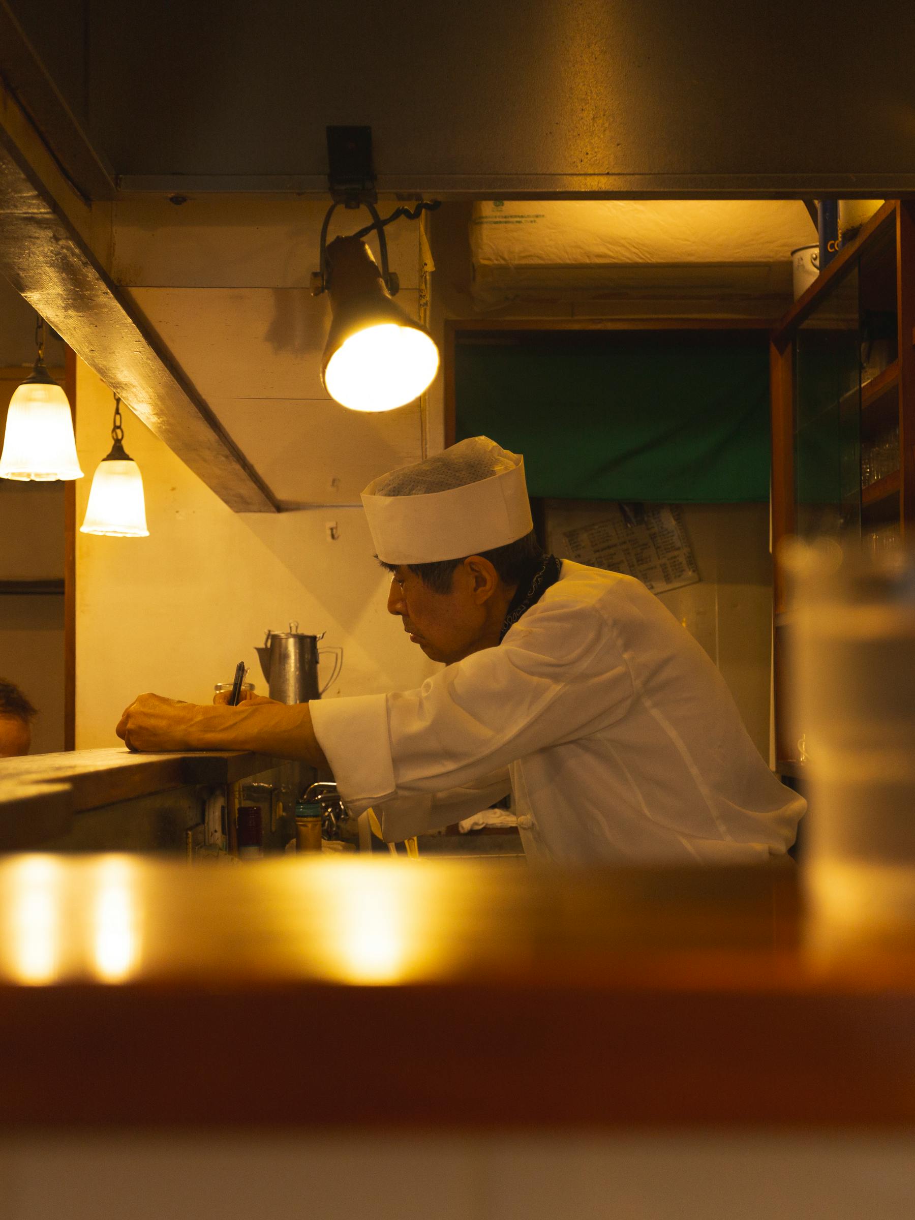 Chef Ren Takahashi at the counter, mid-preparation